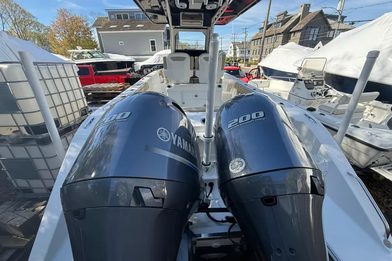 Slide: The Image of 2021 Pursuit S 268 Sport boat with twin Yamaha 200 engines in a marina setting. - 3