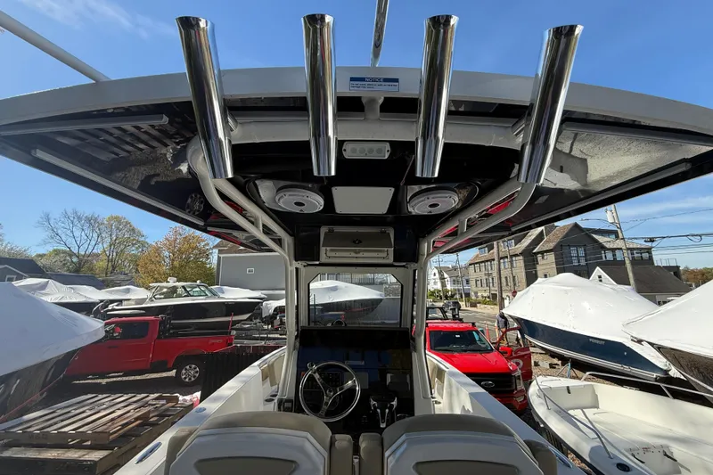 Slide: The Image of 2021 Pursuit S 268 Sport boat interior with rod holders and steering wheel, docked outdoors. - 4