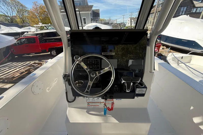 Slide: The Image of 2021 Pursuit S 268 Sport boat helm with steering wheel and controls. - 5