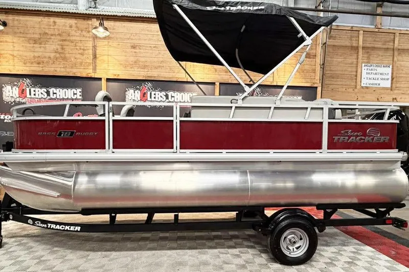 The Image of 2026 Sun Tracker Bass Buggy 18 DLX pontoon boat on display indoors. - 0