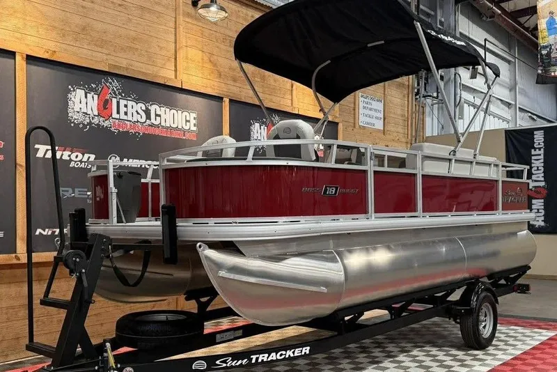 Slide: The Image of 2026 Sun Tracker Bass Buggy 18 DLX pontoon boat displayed indoors. - 3