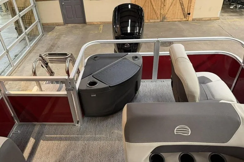 Slide: The Image of 2026 Sun Tracker Bass Buggy 18 DLX interior with seating and motor, in a showroom setting. - 9