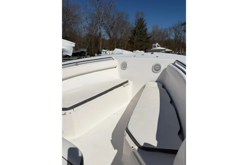 Slide: The Image of 2015 Tidewater 230 CC Adventure boat interior with white seating and clear blue sky. - 12