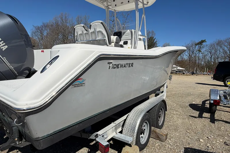 Slide: The Image of 2015 Tidewater 230 CC Adventure boat on trailer, featuring Yamaha engine, parked outdoors. - 4
