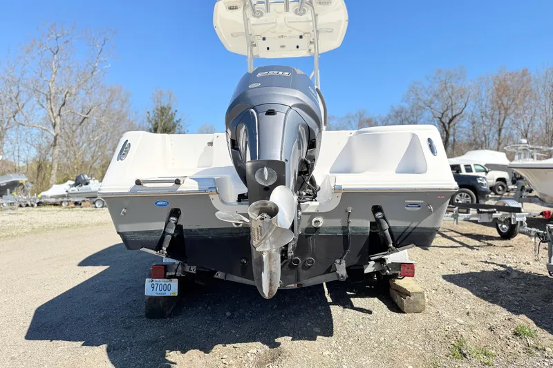Slide: The Image of 2015 Tidewater 230 CC Adventure boat with outboard motor, parked on gravel. - 6