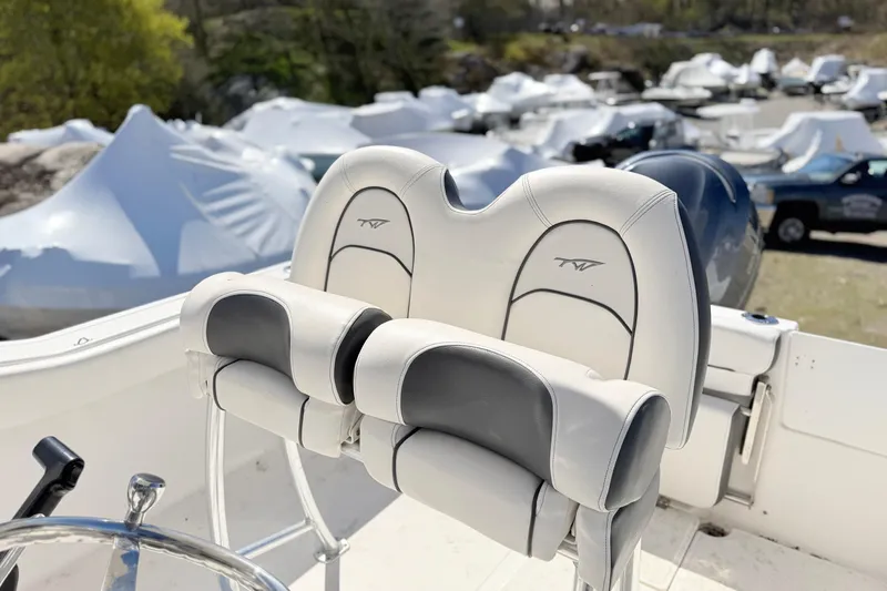 Slide: The Image of 2015 Tidewater 230 CC Adventure boat seats with logo, surrounded by covered boats. - 8