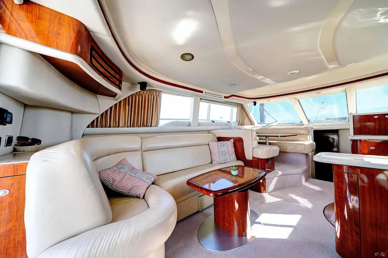 Slide: The Image of Luxurious interior of a 2004 Sea Ray 480 Sedan Bridge yacht with elegant seating and wood finishes. - 11