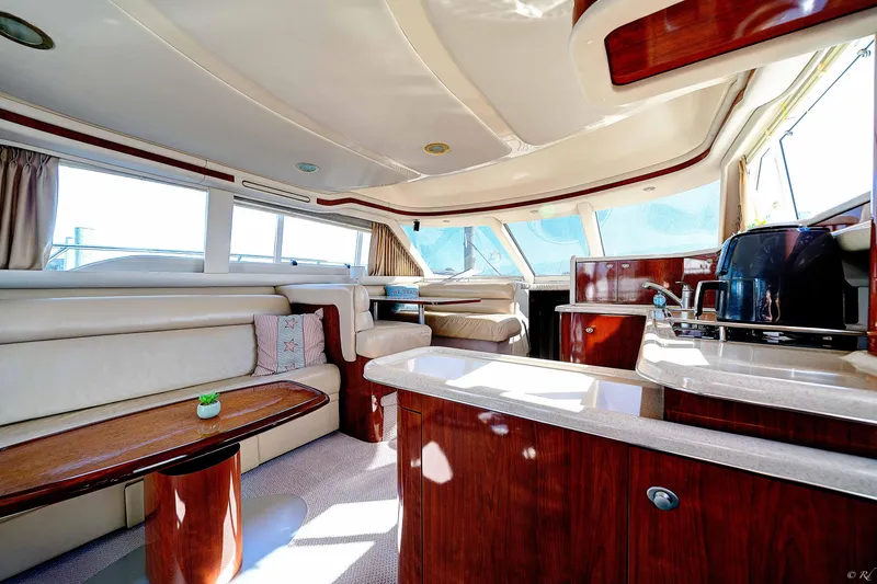 Slide: The Image of Luxurious interior of 2004 Sea Ray 480 Sedan Bridge yacht with elegant seating and kitchen area. - 14