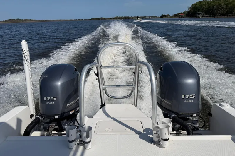 Slide: The Image of 2019 World Cat 230 CC boat with dual Yamaha 115 engines cruising on open water. - 13