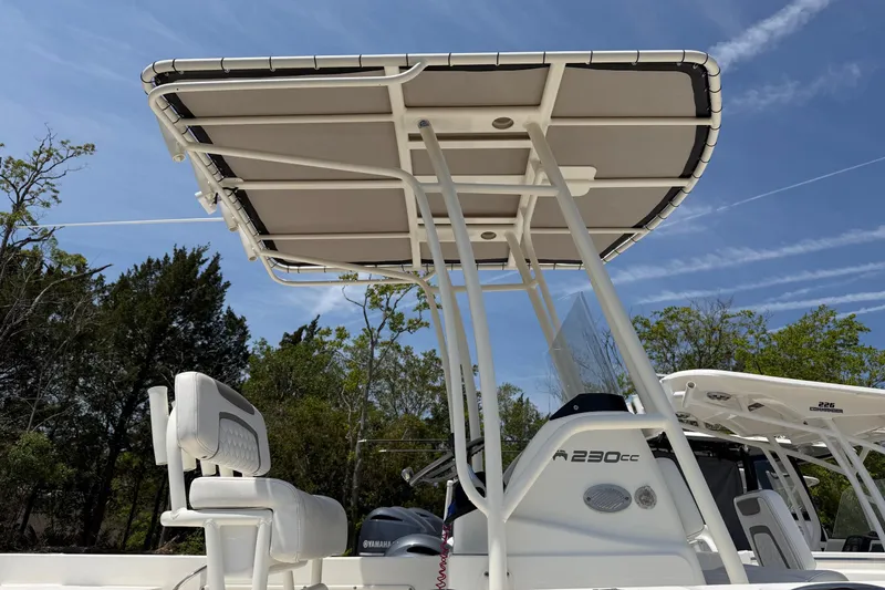 Slide: The Image of 2019 World Cat 230 CC boat with T-top and seating, under clear blue sky. - 14