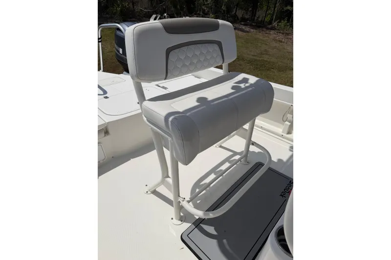 Slide: The Image of White seating on 2019 World Cat 230 CC boat, featuring cushioned backrest and sturdy frame. - 17