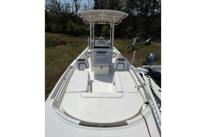Slide: The Image of 2019 World Cat 230 CC boat with spacious deck and seating, parked outdoors. - 18