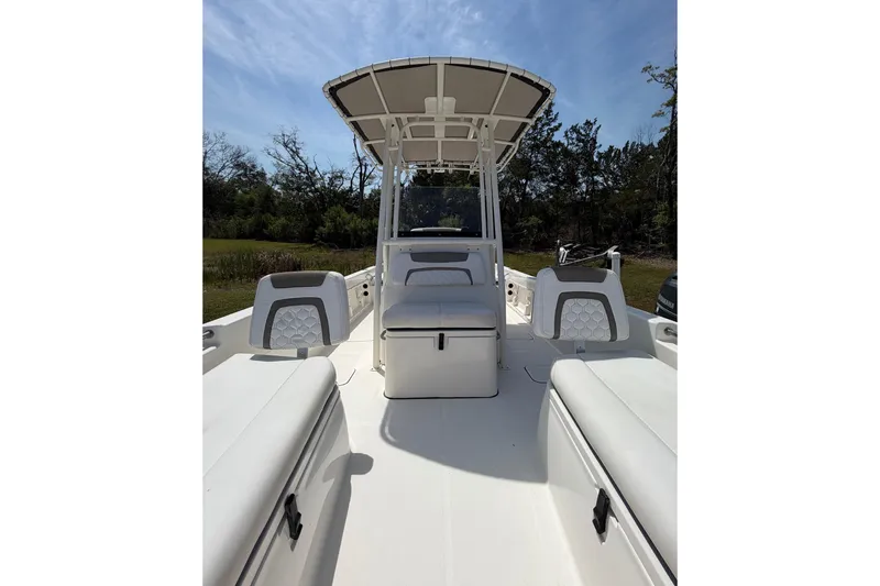 Slide: The Image of 2019 World Cat 230 CC boat interior with seating and canopy under clear sky. - 22