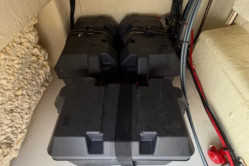 Slide: The Image of Battery compartment of a 2019 World Cat 230 CC boat, featuring secured black battery boxes. - 49