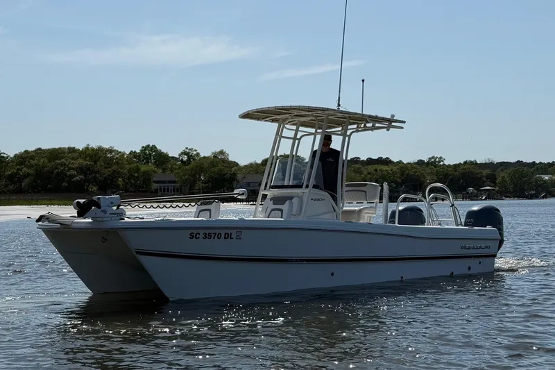 Slide: The Image of 2019 World Cat 230 CC boat on calm water, featuring dual engines and a T-top. - 7