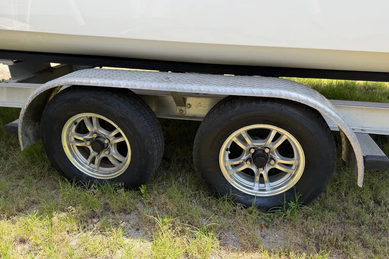 Slide: The Image of Trailer wheels of a 2019 World Cat 230 CC boat on grass. - 70