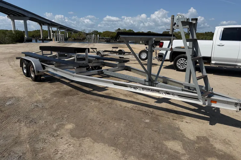 Slide: The Image of Trailer for 2019 World Cat 230 CC boat, parked on sandy ground near a bridge. - 72