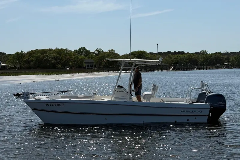 Slide: The Image of 2019 World Cat 230 CC boat on calm water with scenic shoreline background. - 8