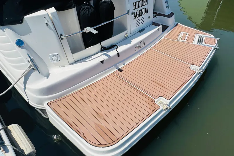 Slide: The Image of 2002 Rinker Fiesta Vee 342 boat with teak swim platform, docked on calm water. - 11