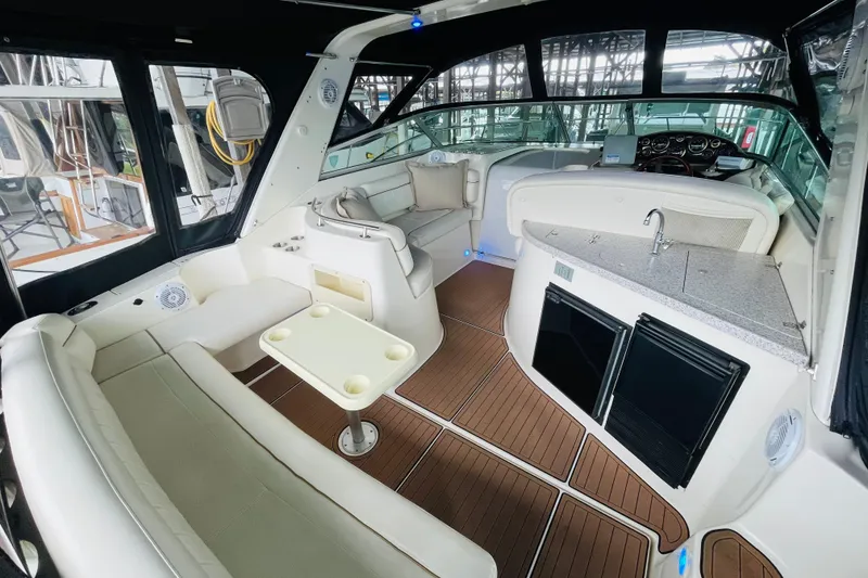 Slide: The Image of 2002 Rinker Fiesta Vee 342 yacht interior with seating, table, and kitchenette. - 12