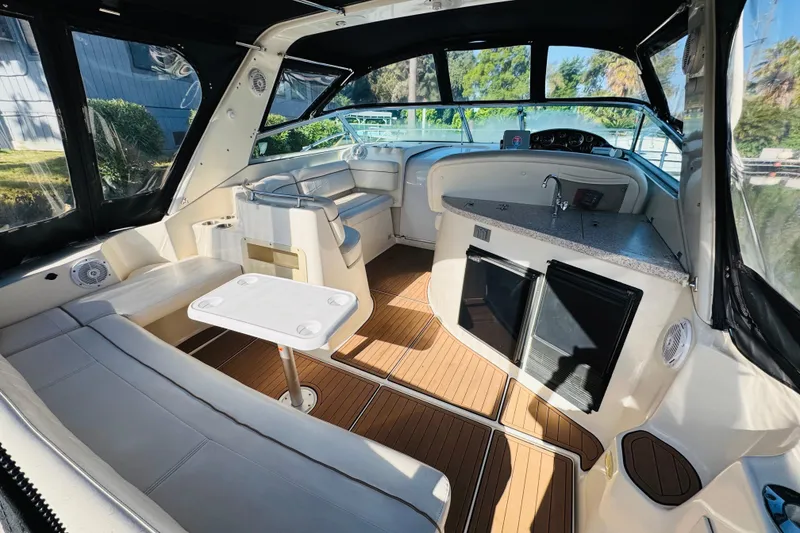 Slide: The Image of 2002 Rinker Fiesta Vee 342 boat interior with seating, table, and kitchenette. - 16