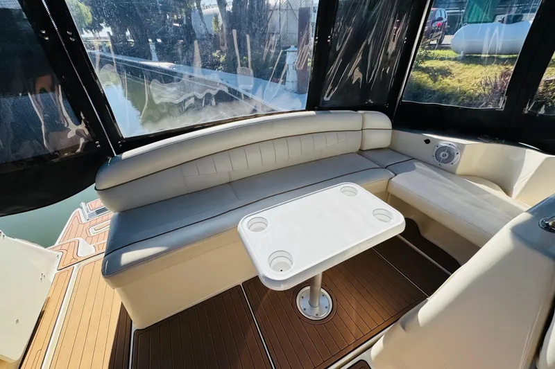 Slide: The Image of 2002 Rinker Fiesta Vee 342 boat interior with cushioned seating and a central table. - 18