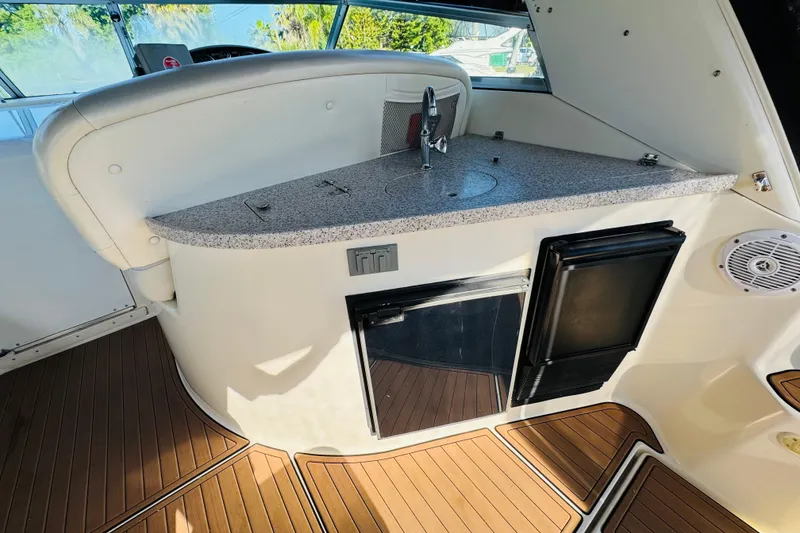 Slide: The Image of 2002 Rinker Fiesta Vee 342 boat interior with kitchenette and wood flooring. - 20