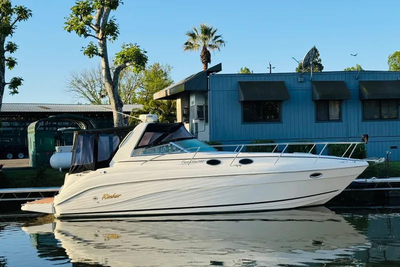 Slide: The Image of 2002 Rinker Fiesta Vee 342 boat docked by a blue building. - 3