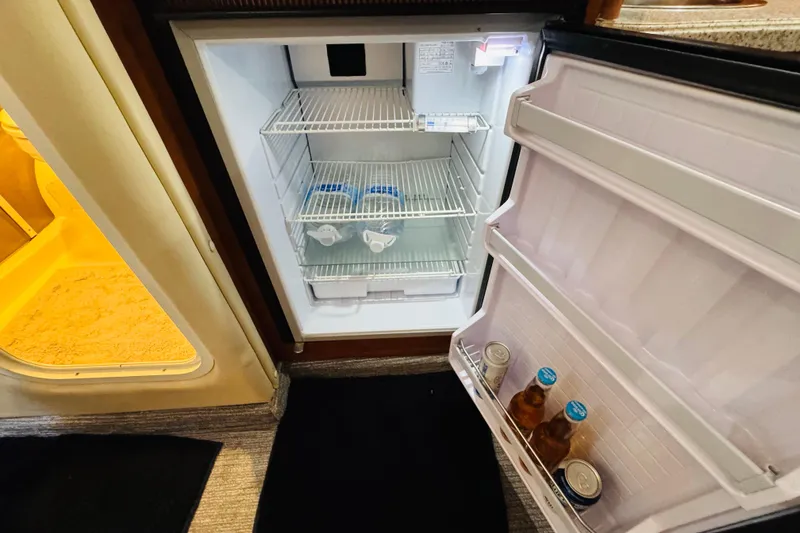 Slide: The Image of 2002 Rinker Fiesta Vee 342 boat interior fridge with drinks and water bottles. - 45