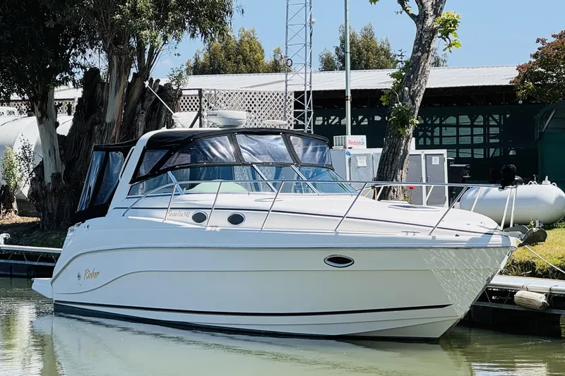 Slide: The Image of 2002 Rinker Fiesta Vee 342 boat docked in a serene marina setting. - 5
