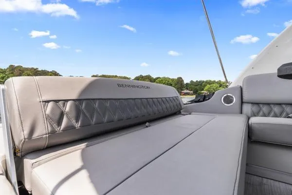 Slide: The Image of 2023 Bennington QX 25 QXSBA boat interior with luxurious seating and scenic background. - 12