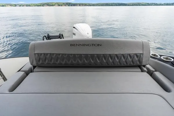 Slide: The Image of 2023 Bennington QX 25 QXSBA boat with luxurious seating on a serene lake. - 23