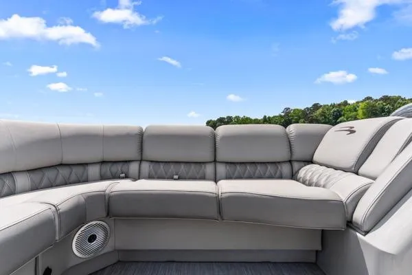 Slide: The Image of 2023 Bennington QX 25 QXSBA boat interior with luxurious seating under a clear blue sky. - 7