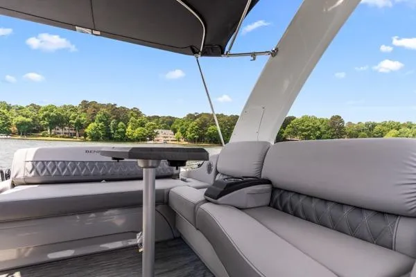 Slide: The Image of 2023 Bennington QX 25 QXSBA pontoon boat interior with plush seating and scenic lake view. - 9