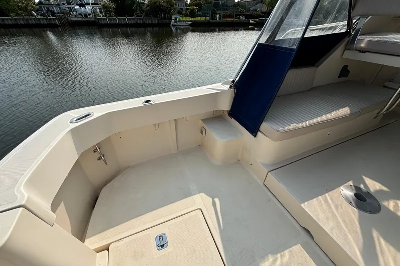 Slide: The Image of 2005 Mainship Pilot 30-II Sedan boat deck with seating, overlooking calm waters. - 10