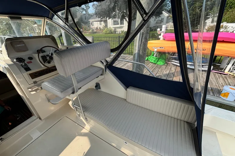 Slide: The Image of 2005 Mainship Pilot 30-II Sedan interior with helm, seating, and clear canopy. - 12