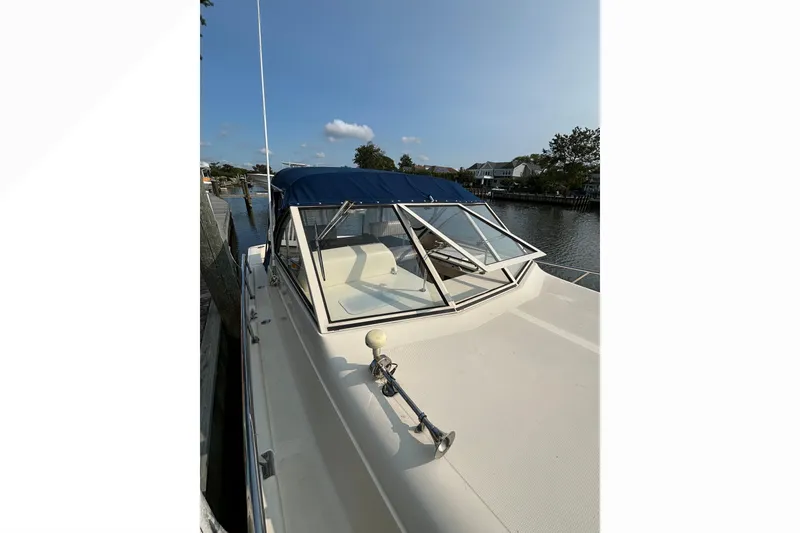 Slide: The Image of 2005 Mainship Pilot 30-II Sedan boat docked by a serene waterfront. - 2
