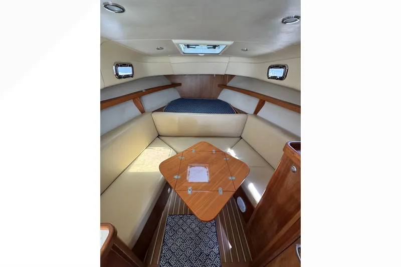 Slide: The Image of 2005 Mainship Pilot 30-II Sedan interior with cozy seating and wooden table. - 24