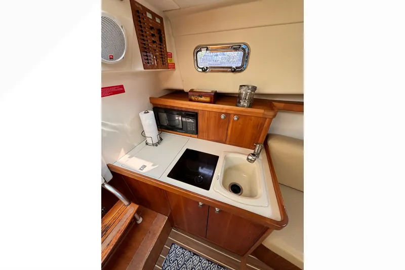 Slide: The Image of 2005 Mainship Pilot 30-II Sedan galley with sink, stove, and microwave. - 25
