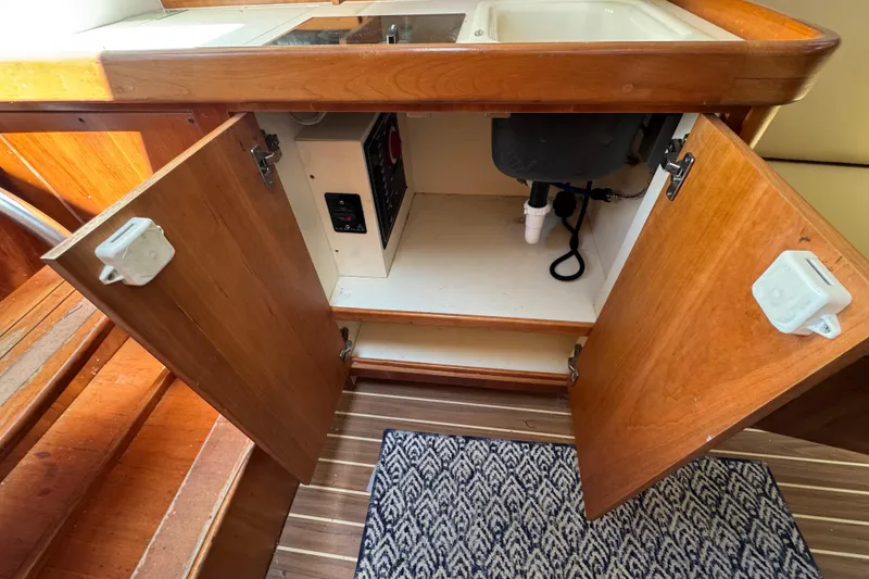 Slide: The Image of Open cabinet under sink in 2005 Mainship Pilot 30-II Sedan boat interior. - 27