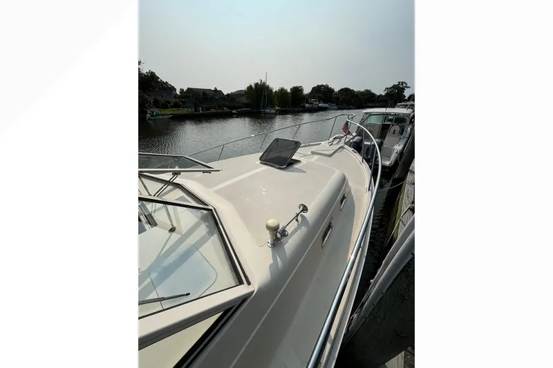 Slide: The Image of 2005 Mainship Pilot 30-II Sedan docked by a serene waterfront. - 3
