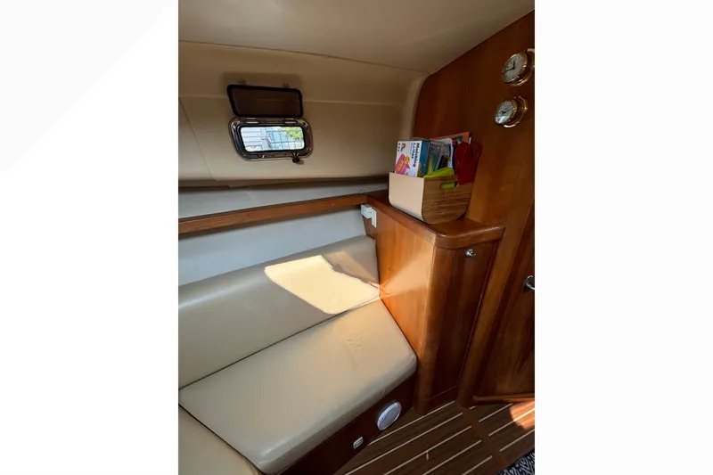 Slide: The Image of Interior of 2005 Mainship Pilot 30-II Sedan with beige seating and wooden accents. - 30