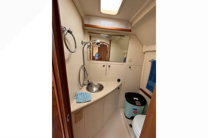 Slide: The Image of 2005 Mainship Pilot 30-II Sedan bathroom with sink, mirror, and storage cabinets. - 31