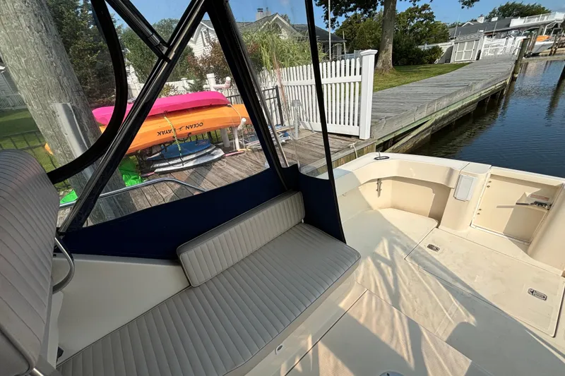 Slide: The Image of 2005 Mainship Pilot 30-II Sedan boat interior with dockside view and colorful kayaks. - 6