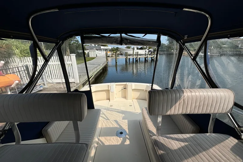 Slide: The Image of 2005 Mainship Pilot 30-II Sedan interior with dockside view and cushioned seating. - 7