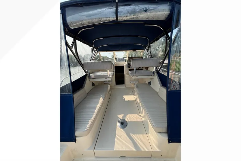 Slide: The Image of 2005 Mainship Pilot 30-II Sedan interior with blue canopy and white seating. - 8
