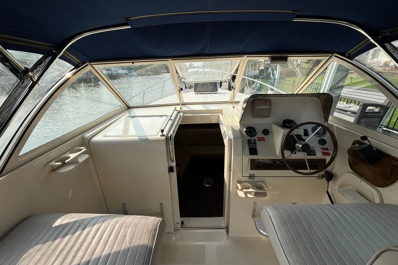 Slide: The Image of 2005 Mainship Pilot 30-II Sedan interior with helm, seating, and water view. - 9