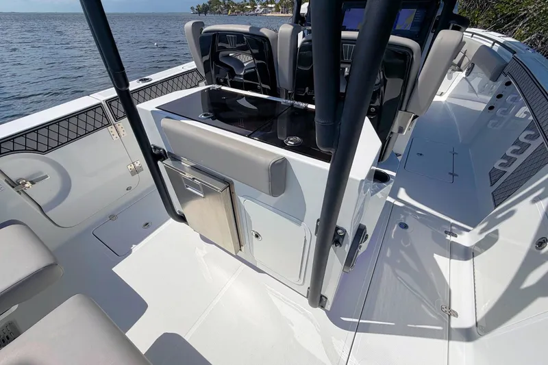 Slide: The Image of 2021 Wellcraft 302 Fisherman boat interior with seating and storage, on a sunny day. - 13