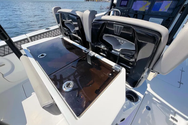 Slide: The Image of 2021 Wellcraft 302 Fisherman boat interior with seating and control panel, on calm water. - 14