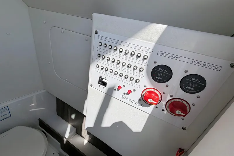 Slide: The Image of Control panel of 2021 Wellcraft 302 Fisherman boat, featuring battery switches and circuit breakers. - 18